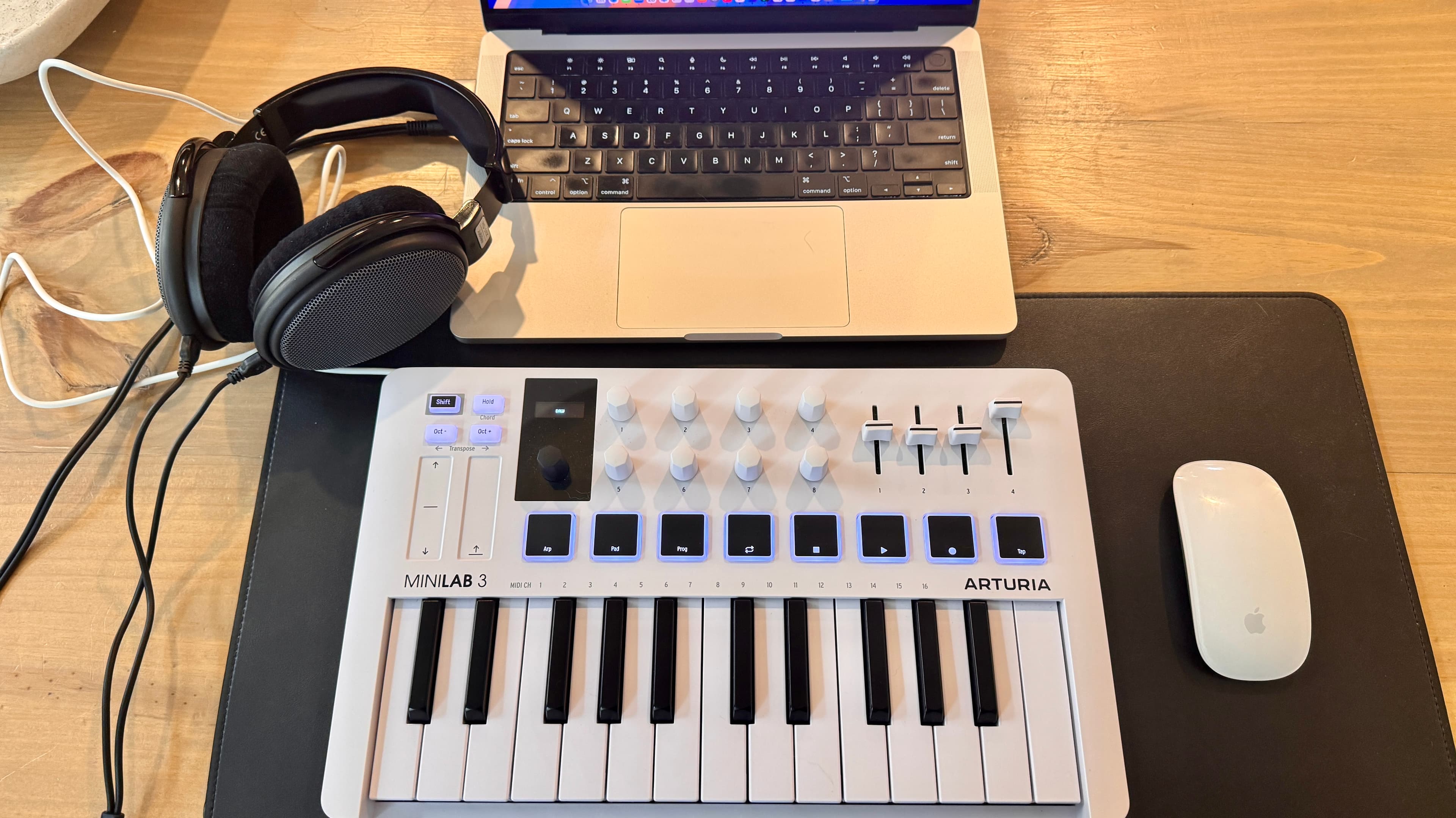 A synthesizer keyboard, headphones, and a laptop