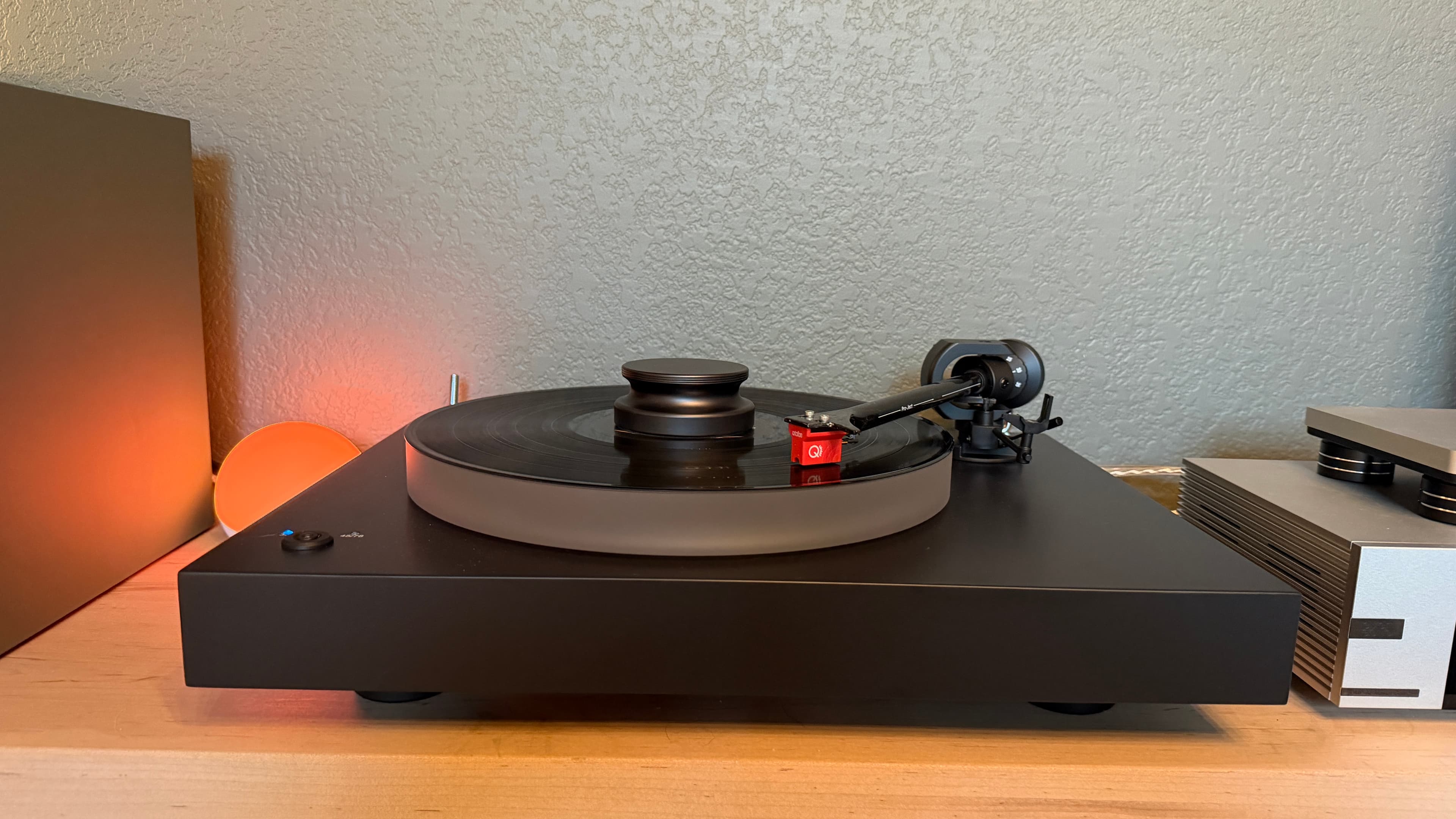 A turntable and speaker under warm light