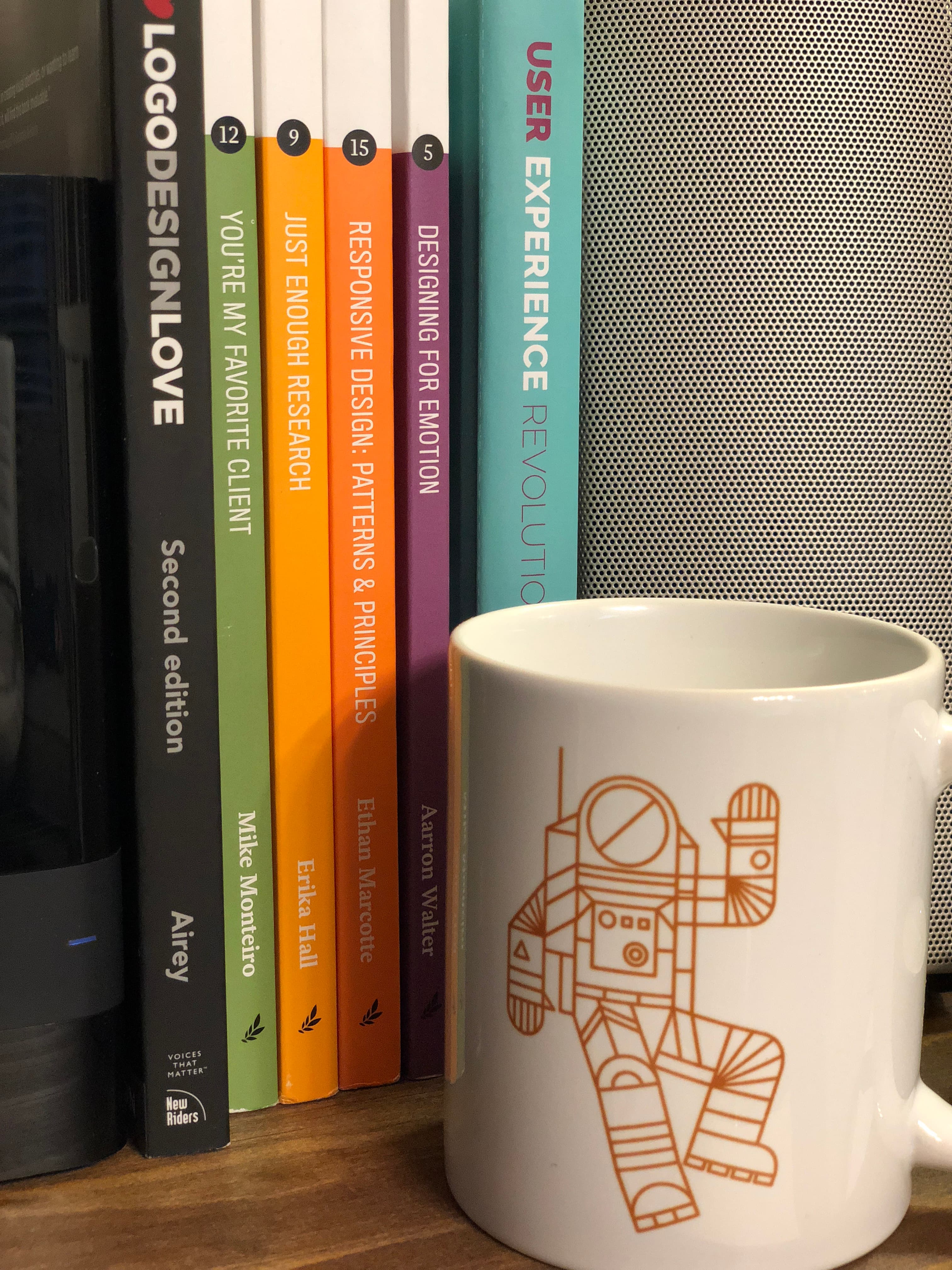 A UX design mug next to a stack of design books