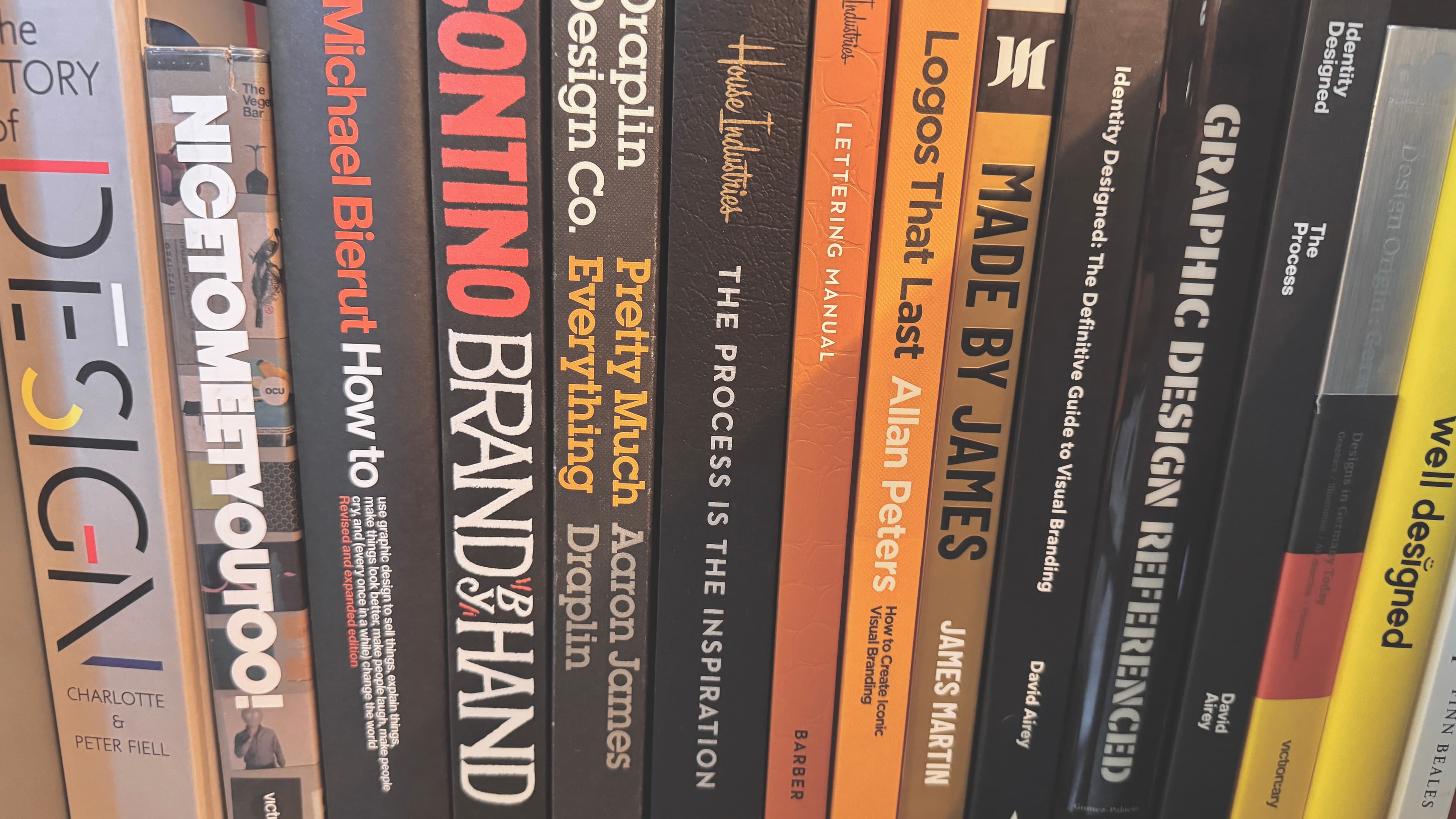 A close-up of design book spines on a shelf
