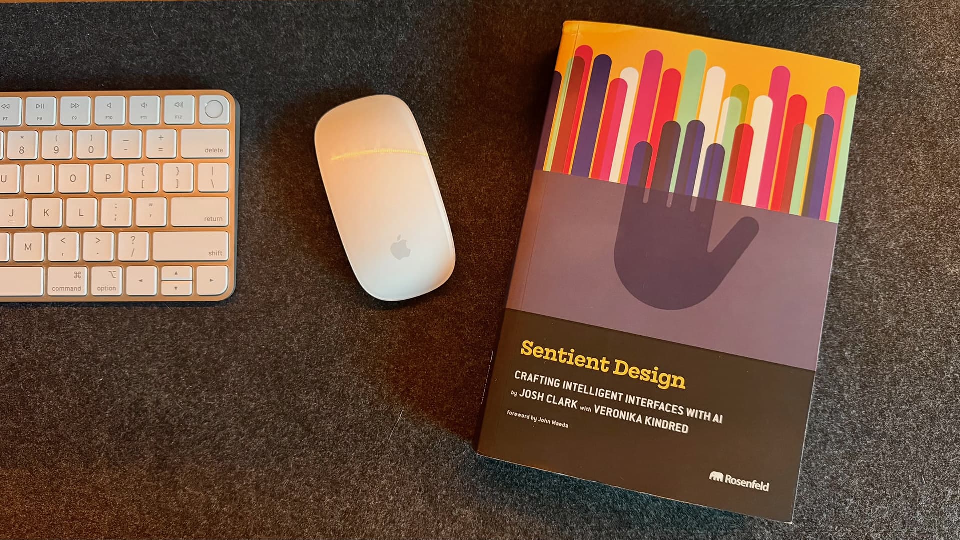 Sentient Design by Josh Clark and Veronika Kindred, on a desk beside a keyboard and mouse